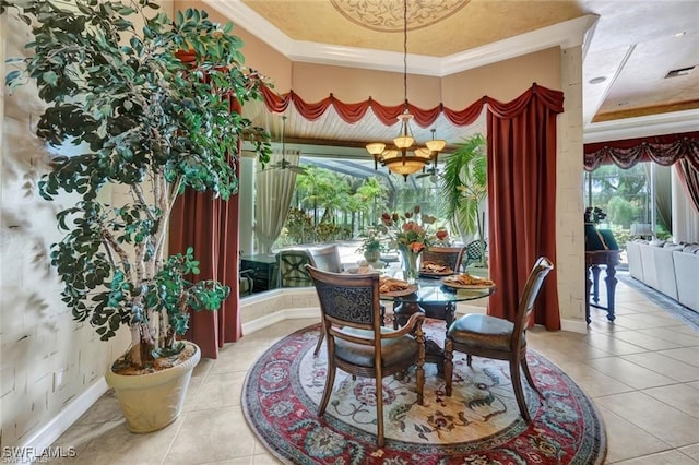 tiled dining space with a raised ceiling, an inviting chandelier, and ornamental molding