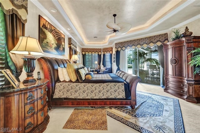 bedroom featuring access to exterior, light carpet, a tray ceiling, and crown molding