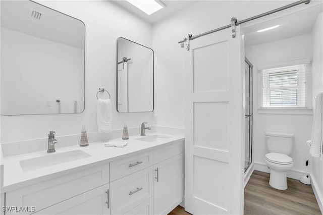 bathroom featuring hardwood / wood-style flooring, vanity, an enclosed shower, and toilet