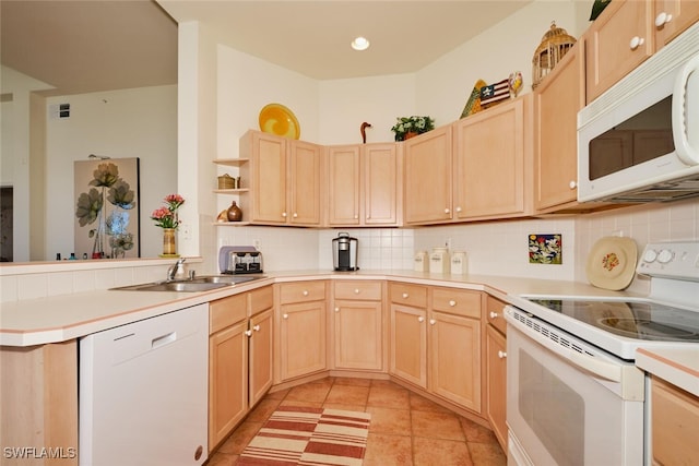 kitchen featuring kitchen peninsula, white appliances, sink, light brown cabinets, and light tile patterned floors