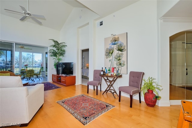 living room featuring ceiling fan, wood-type flooring, and high vaulted ceiling