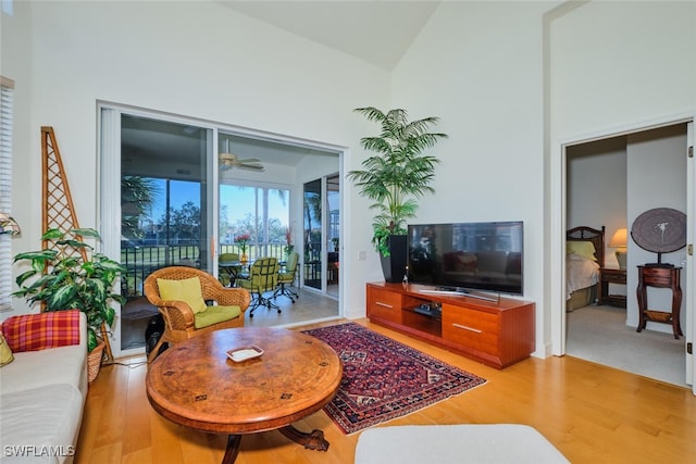 living room with hardwood / wood-style floors, ceiling fan, and vaulted ceiling