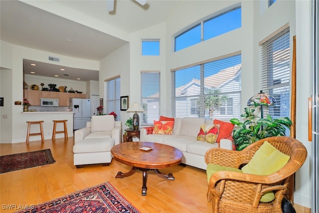 living room with ceiling fan and light hardwood / wood-style flooring