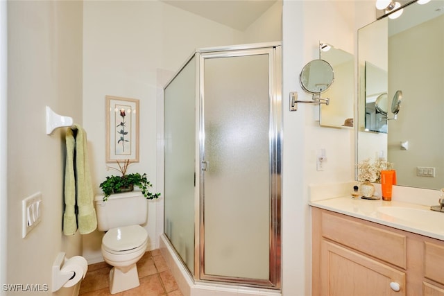 bathroom featuring tile patterned flooring, vanity, a shower with shower door, and toilet