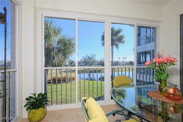 sunroom / solarium featuring a water view