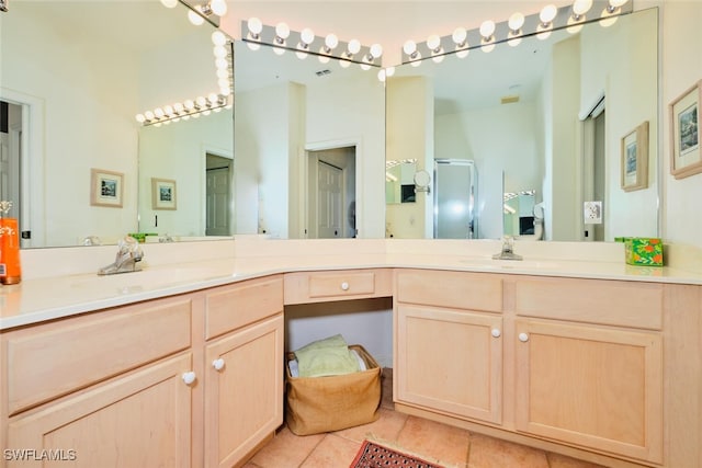 bathroom with tile patterned flooring, vanity, and walk in shower