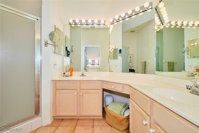 bathroom with tile patterned floors, vanity, and walk in shower