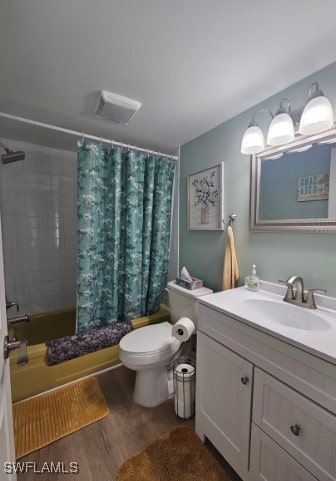 full bathroom featuring hardwood / wood-style flooring, shower / bath combination with curtain, toilet, and vanity