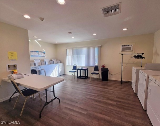 dining space featuring a wall mounted AC, dark hardwood / wood-style flooring, and independent washer and dryer