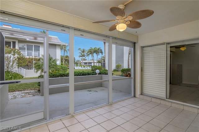 unfurnished sunroom featuring ceiling fan