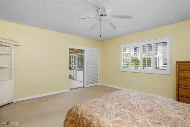 carpeted bedroom with a textured ceiling, ceiling fan, access to outside, and multiple windows