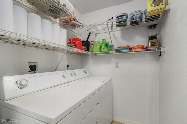 laundry area featuring laundry area, baseboards, and washer and dryer