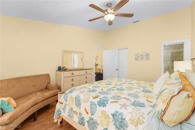 bedroom with ceiling fan, wood-type flooring, and connected bathroom