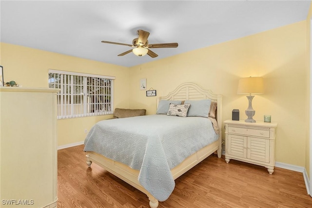 bedroom with a ceiling fan, light wood-style flooring, and baseboards