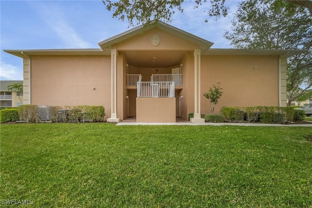 exterior space with a yard, a balcony, and stucco siding