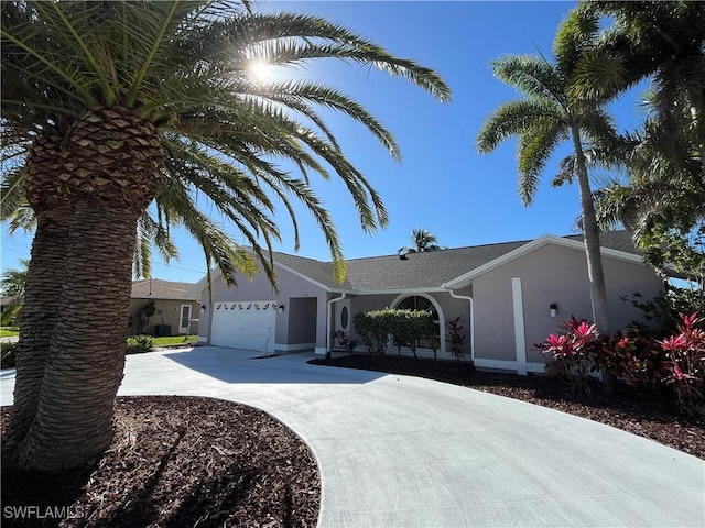 view of front of home with a garage, concrete driveway, and stucco siding