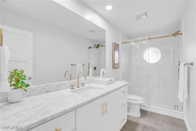 bathroom featuring vanity, toilet, and a shower with door