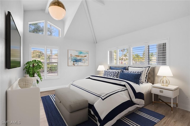 bedroom featuring high vaulted ceiling and light hardwood / wood-style flooring