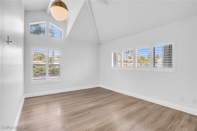 spare room featuring light hardwood / wood-style flooring and high vaulted ceiling