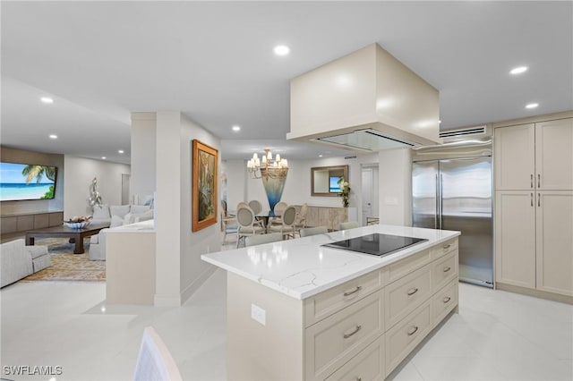 kitchen featuring black electric stovetop, light stone counters, custom range hood, a center island, and built in refrigerator