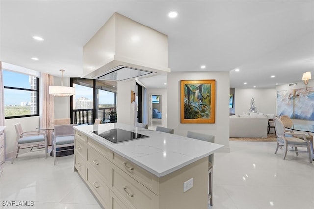 kitchen featuring a center island, black electric stovetop, decorative light fixtures, a kitchen bar, and island exhaust hood