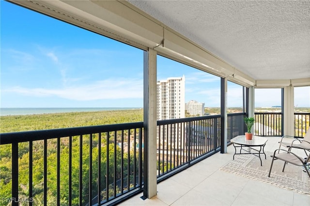 sunroom / solarium featuring a wealth of natural light and a water view