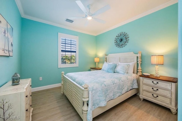 bedroom featuring ceiling fan, crown molding, and light hardwood / wood-style floors