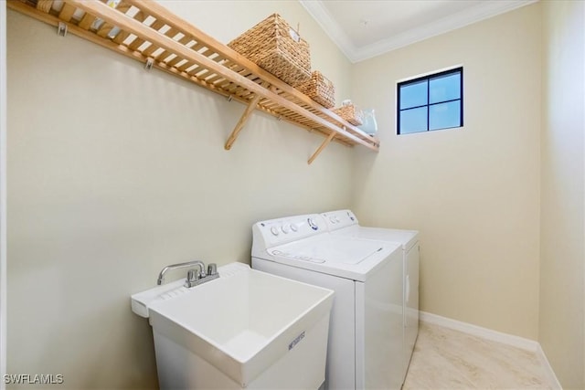 laundry area featuring sink, washing machine and dryer, and crown molding