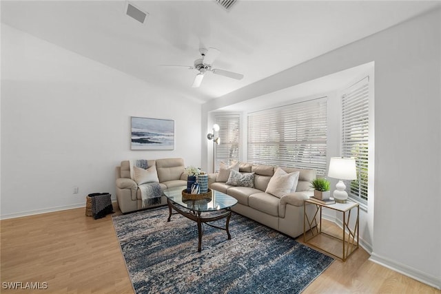 living room with ceiling fan, hardwood / wood-style floors, and vaulted ceiling