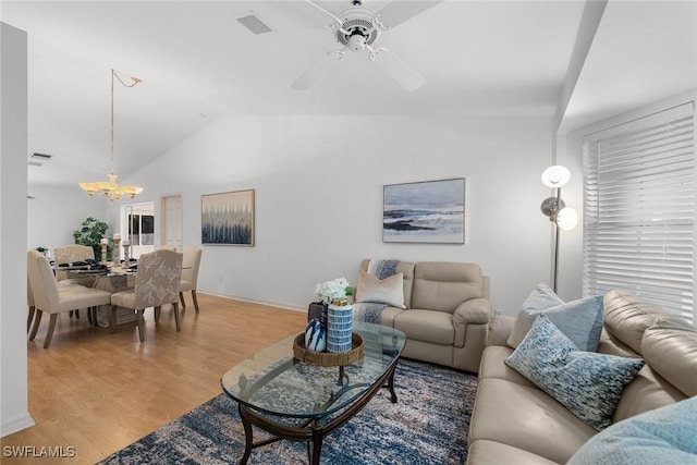 living room featuring ceiling fan with notable chandelier, light hardwood / wood-style flooring, and lofted ceiling