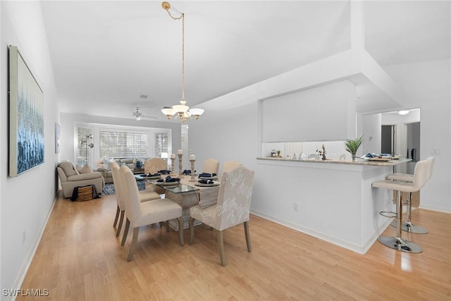 dining space featuring ceiling fan with notable chandelier and light hardwood / wood-style floors