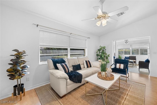 living room featuring ceiling fan, light hardwood / wood-style floors, and vaulted ceiling