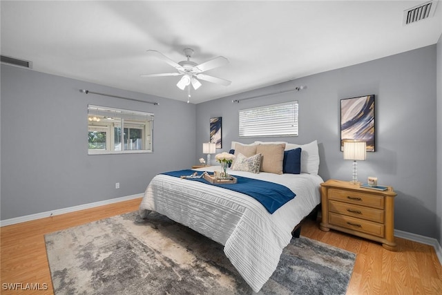 bedroom with multiple windows, hardwood / wood-style floors, and ceiling fan