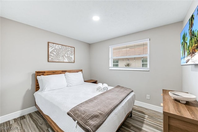 bedroom with dark hardwood / wood-style floors