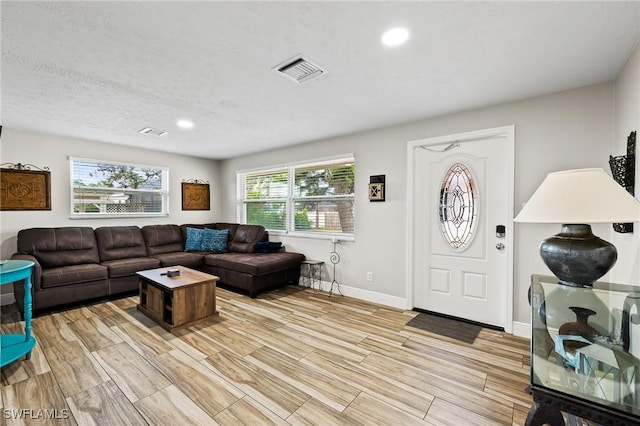 living room featuring a textured ceiling and plenty of natural light