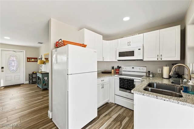 kitchen featuring white cabinetry, light stone counters, white appliances, and sink