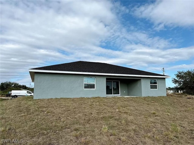 rear view of property featuring a yard