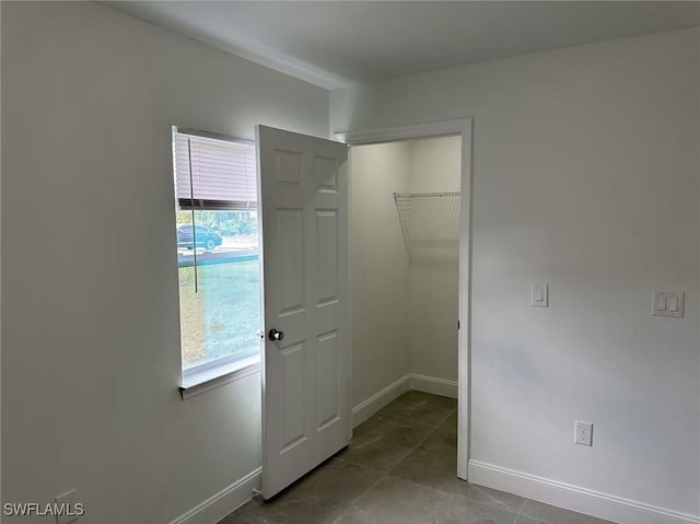 unfurnished bedroom with tile patterned floors, multiple windows, and a closet