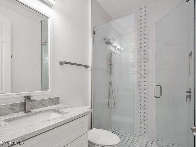 bathroom featuring vanity, toilet, and a shower with shower door