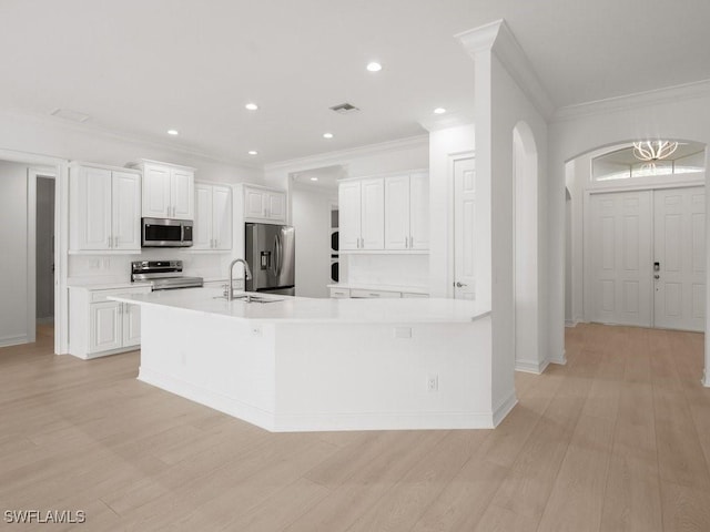 kitchen featuring light wood-type flooring, white cabinets, and appliances with stainless steel finishes