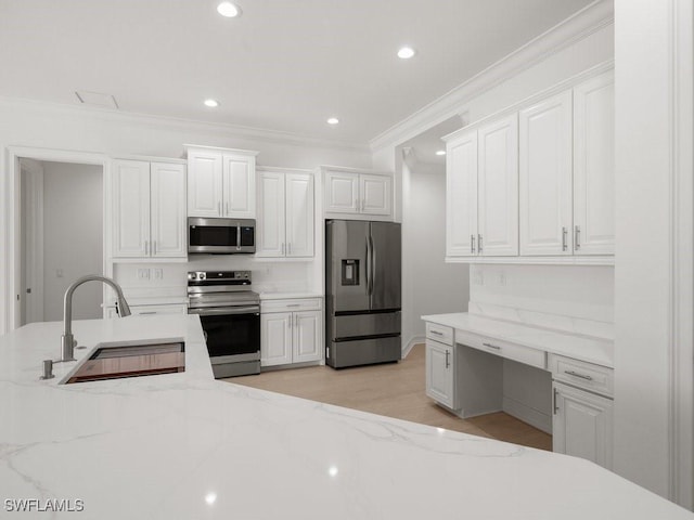 kitchen with sink, stainless steel appliances, white cabinets, and light stone countertops