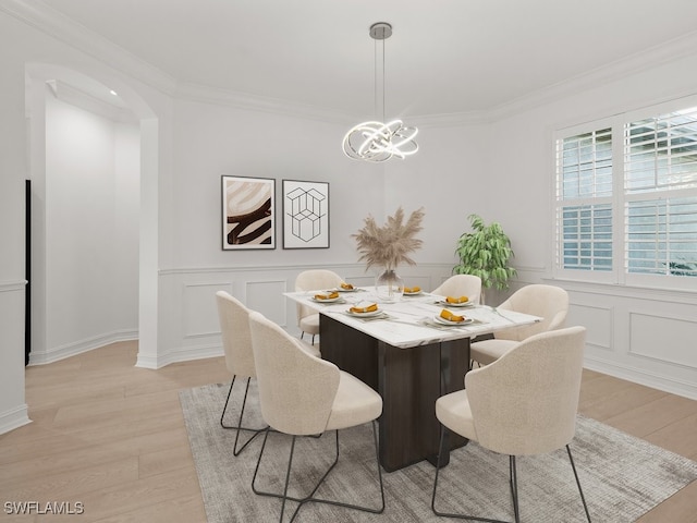 dining room featuring crown molding, a chandelier, and light hardwood / wood-style floors