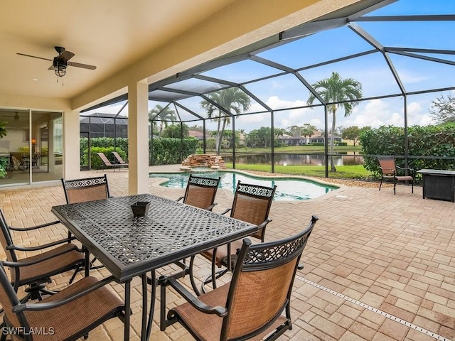 view of patio / terrace featuring a lanai, ceiling fan, and a water view