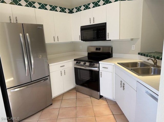 kitchen with white cabinetry, sink, light tile patterned floors, and stainless steel appliances