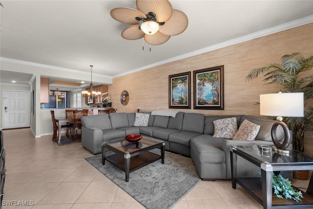 living room with light tile patterned floors, ornamental molding, and ceiling fan with notable chandelier