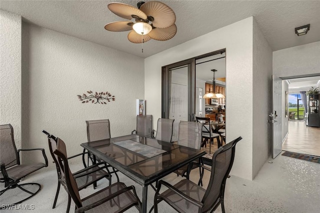 dining area featuring a textured ceiling and ceiling fan