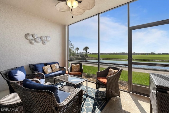 sunroom featuring a water view and ceiling fan