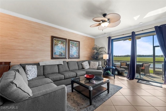 tiled living room featuring ceiling fan, crown molding, and a water view