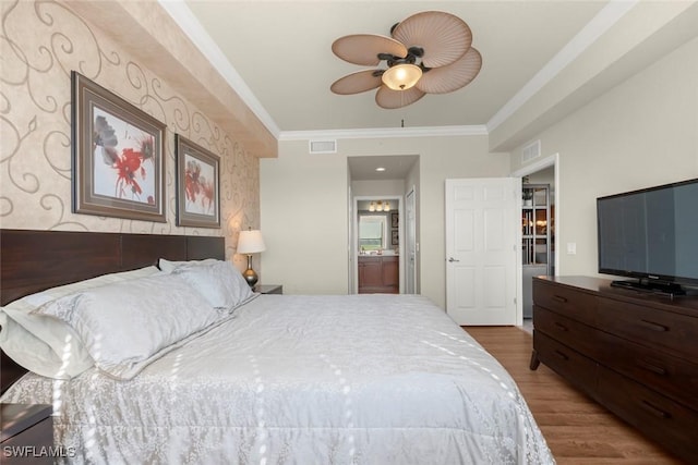 bedroom featuring ensuite bathroom, ceiling fan, ornamental molding, and wood-type flooring