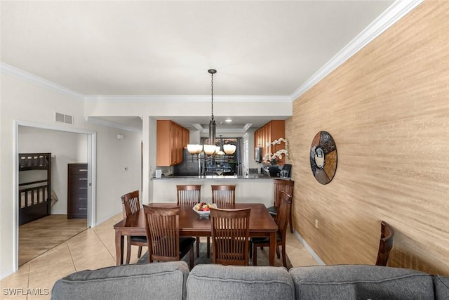 tiled dining space featuring crown molding and a chandelier